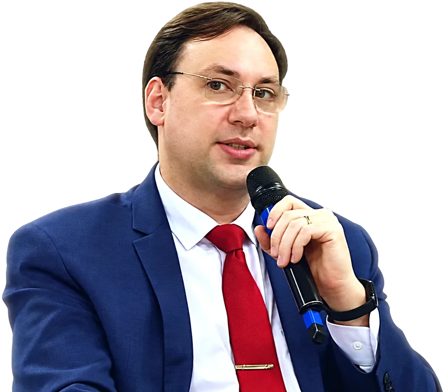 Dr. Fábio Porto, de terno azul e gravata vermelha, falando ao microfone